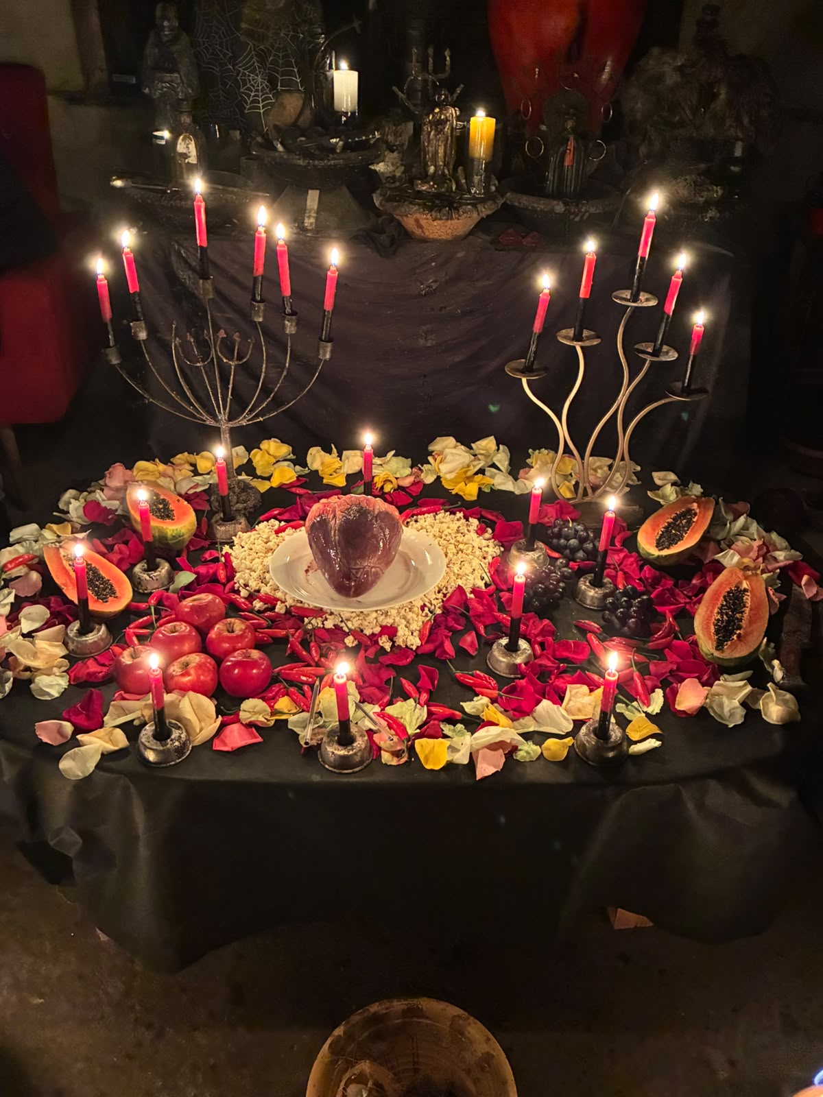 Mesa ritual montada com velas, flores e oferendas